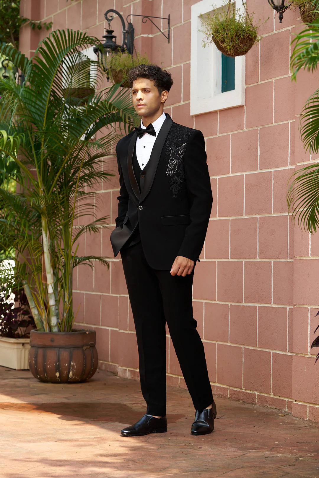 Black partywear suit with handwork design of bird on shoulder