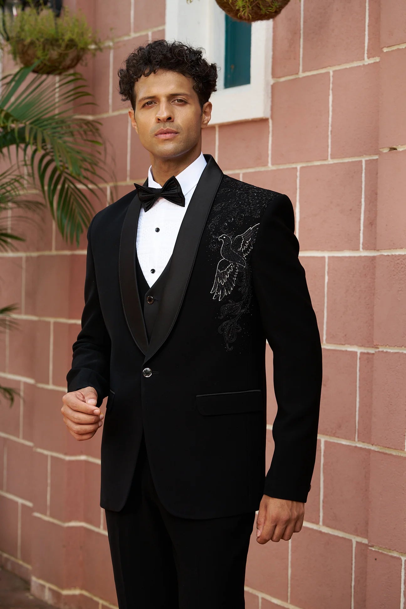 Black partywear suit with handwork design of bird on shoulder