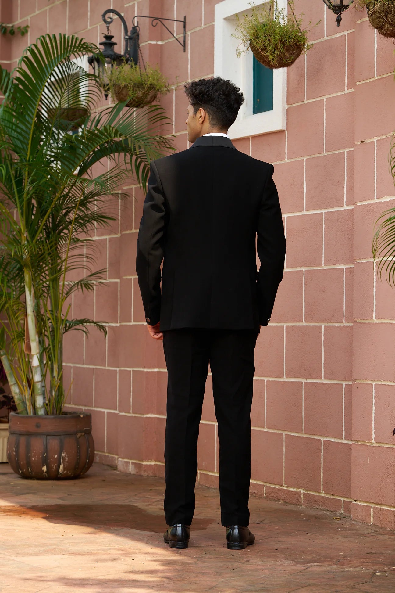 Black partywear suit with handwork design of bird on shoulder